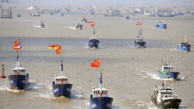 Fishing boats are seen departing from Shenjiawan port towards the East China Sea, in Zhoushan